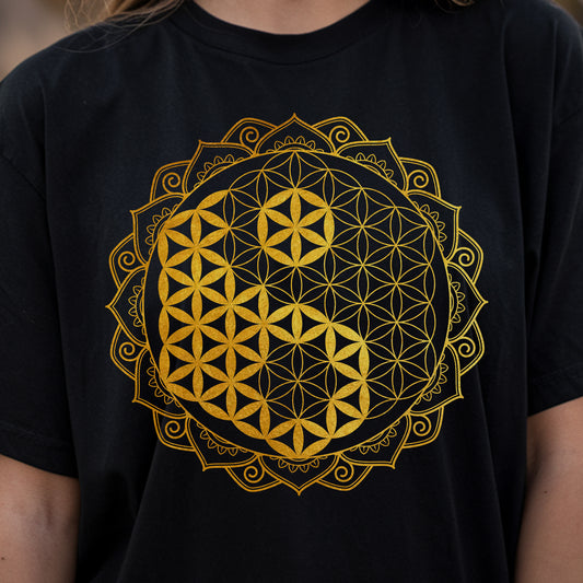 a woman wearing a t - shirt with a flower of life design on it